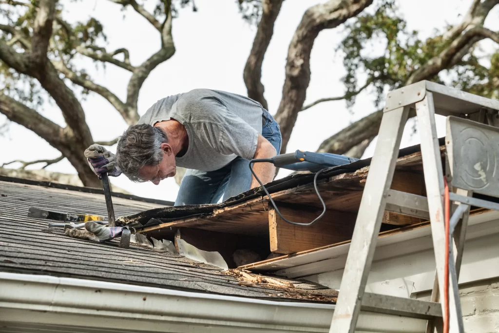 A My Roofing Crew team member on a roof accessing damage to a roof after a storm.